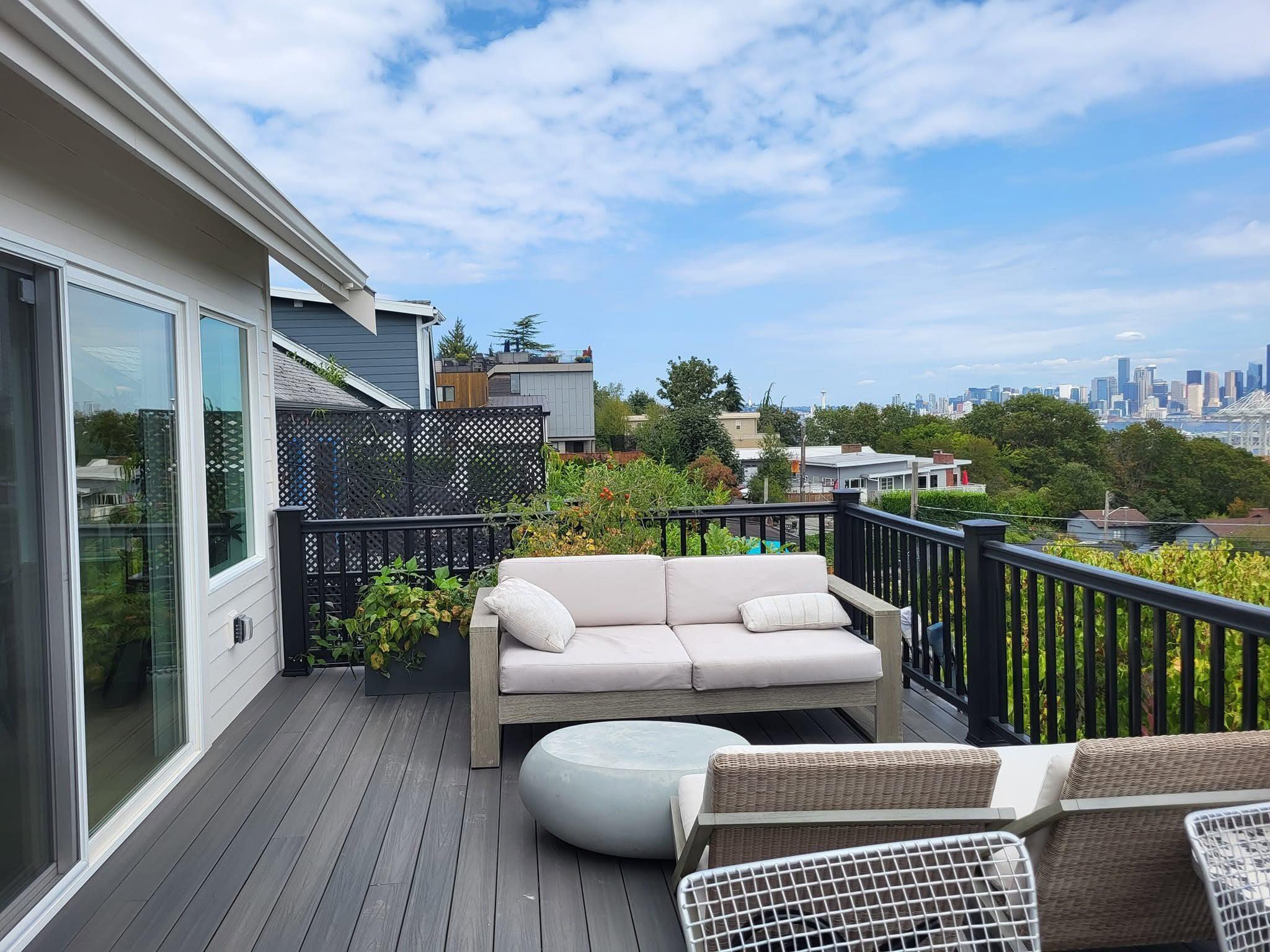 Composite rooftop deck with black railing and a city view