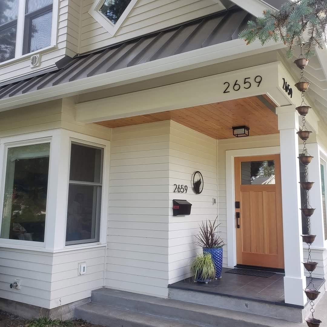 Craftsman front porch with cedar ceiling and a wood front door