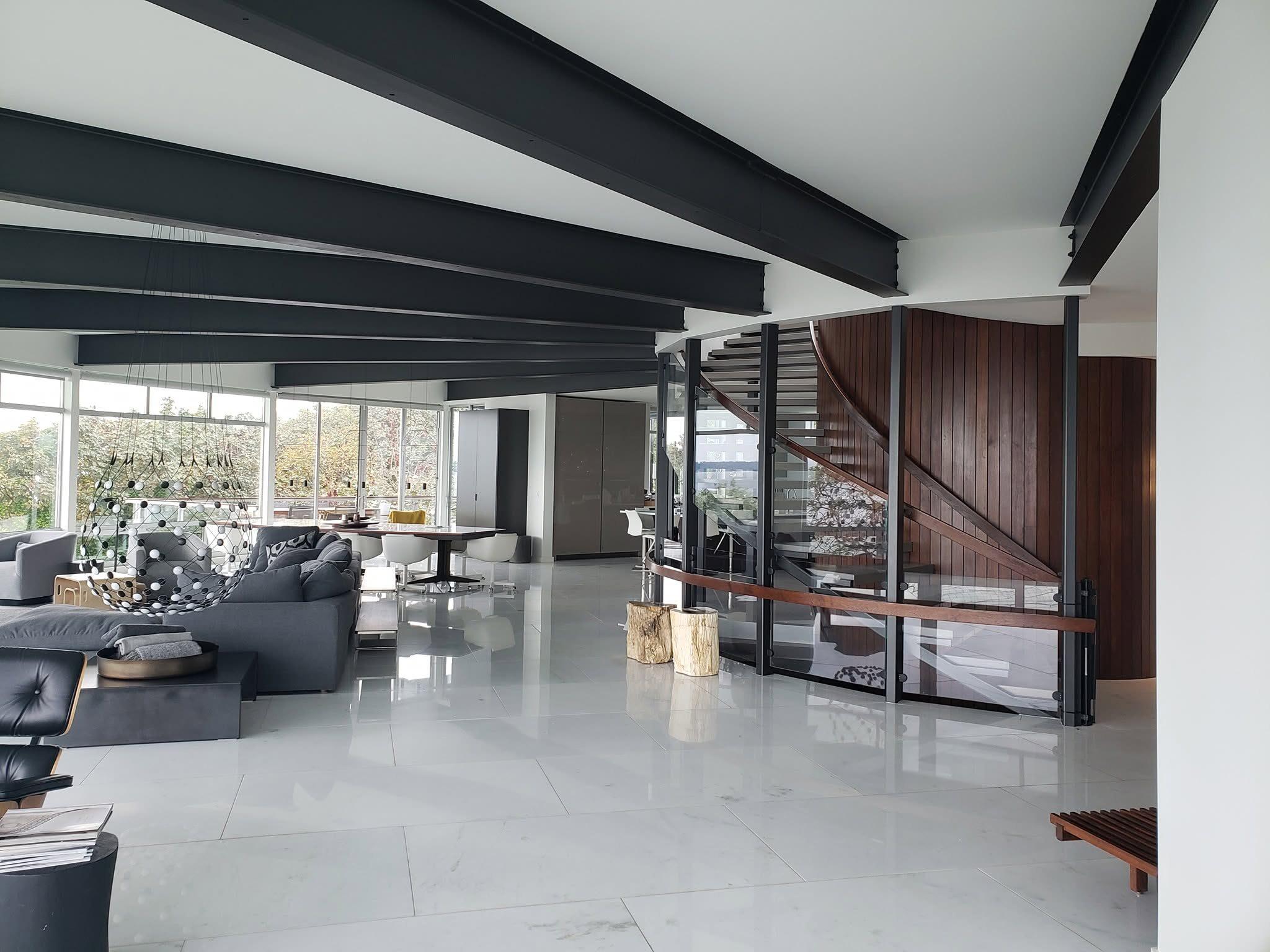 Living space with a curved glass and wood staircase