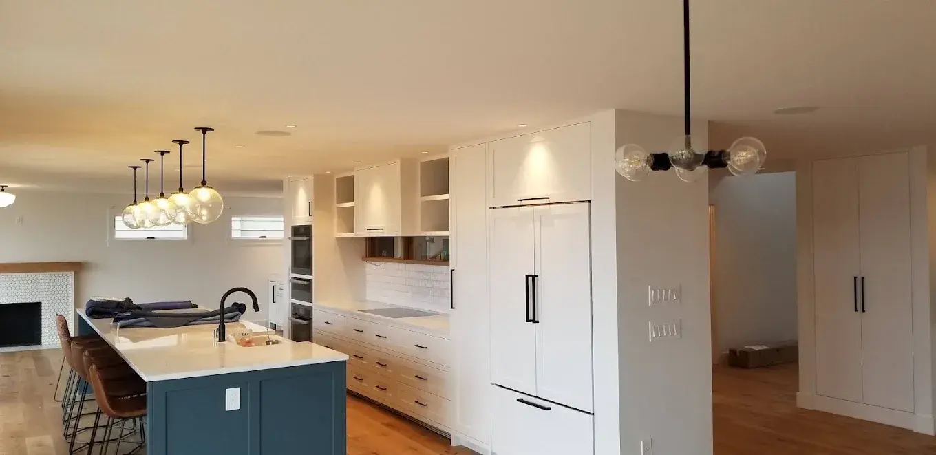Kitchen with floor-to-ceiling white cabinetry and a navy island