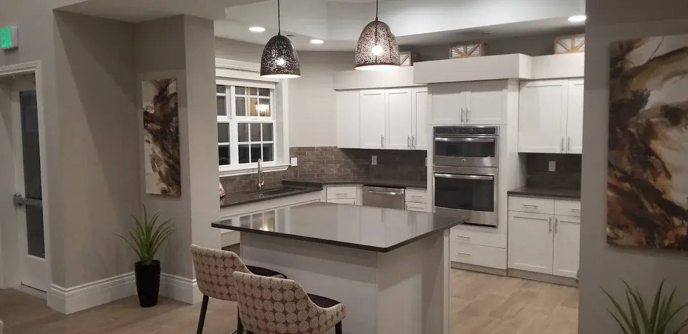 Kitchen with a large island, dark counters and built-in wall ovens