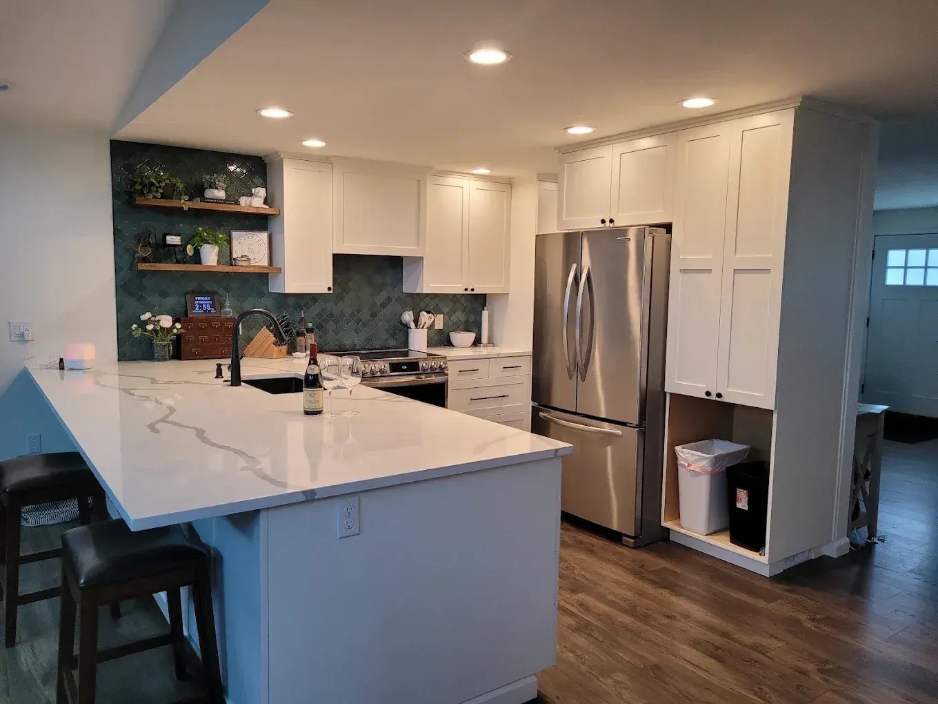 Kitchen with white shaker cabinets, quartz island and open shelving